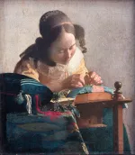 A woman in a yellow dress concentrates on making bobbin lace, her hands close to the threads.